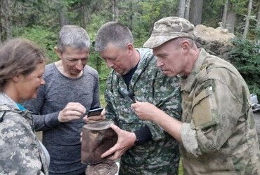 Valentina Palkina, Shura Aleeksenkov, Sergey Ipatov and Aleksey Komanyov (aka Korolyov) examine an old tin can found at the possible location of the 1959 searcher's camp, which Shura Alekseenkov is investigating